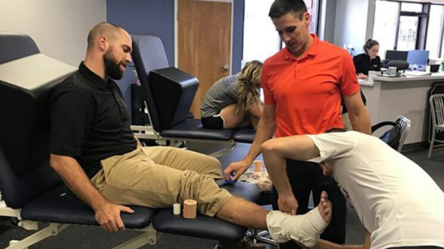 A Physical Therapist administers a foot wrap.