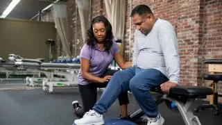 Therapist assessing male patient knee long left aligned